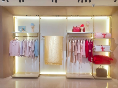 Silk pajamas, scarves and gift boxes displayed on illuminated shop shelves Silk pajamas, scarves and gift boxes displayed on illuminated shop shelves