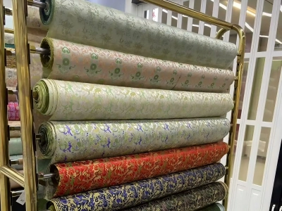 Rolled silk fabrics with traditional patterns displayed on metal racks inside a silk shop Rolled silk fabrics with traditional patterns displayed on metal racks inside a silk shop