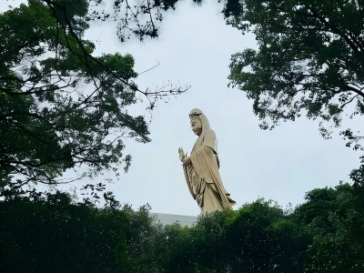 South China Sea Guanyin Statue on Putuo Mountain framed by green trees South China Sea Guanyin Statue on Putuo Mountain framed by green trees