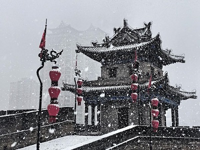 Snow-covered Xi'an Ancient City Wall watchtower with red lanterns. Snow-covered Xi'an Ancient City Wall watchtower with red lanterns.