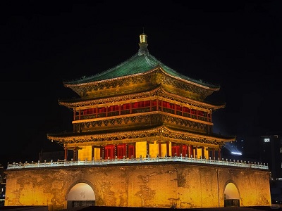 Xi'an Bell Tower illuminated at night against a dark sky.