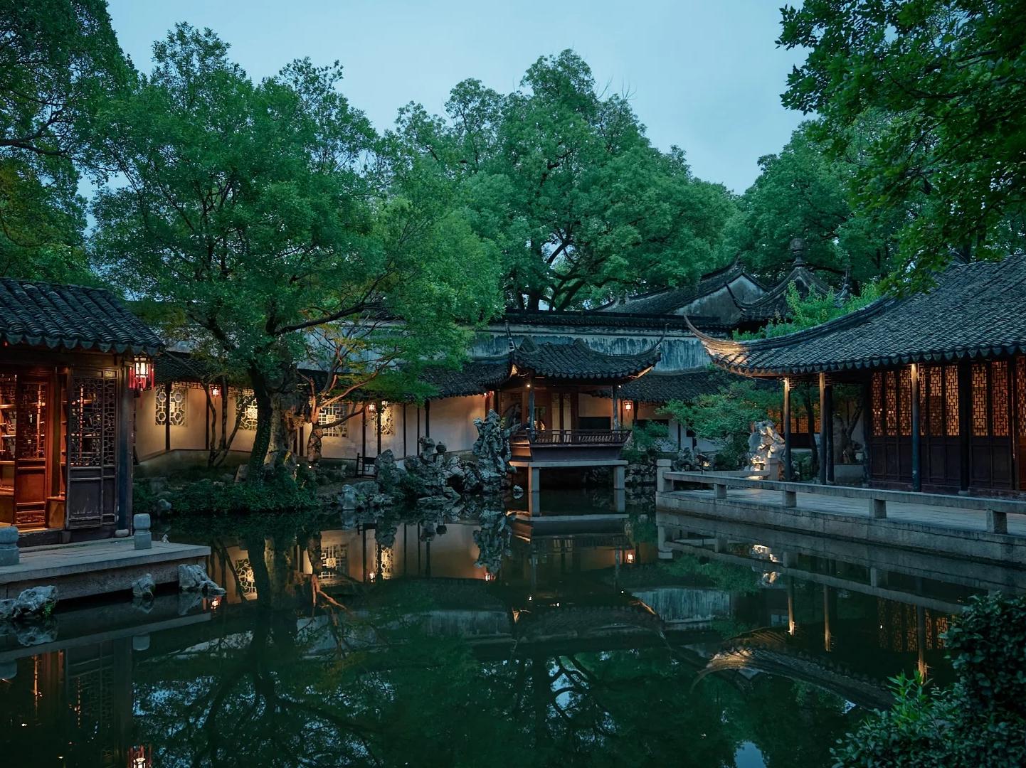 Nightfall view of illuminated classical Retreat and Reflection Garden in Suzhou