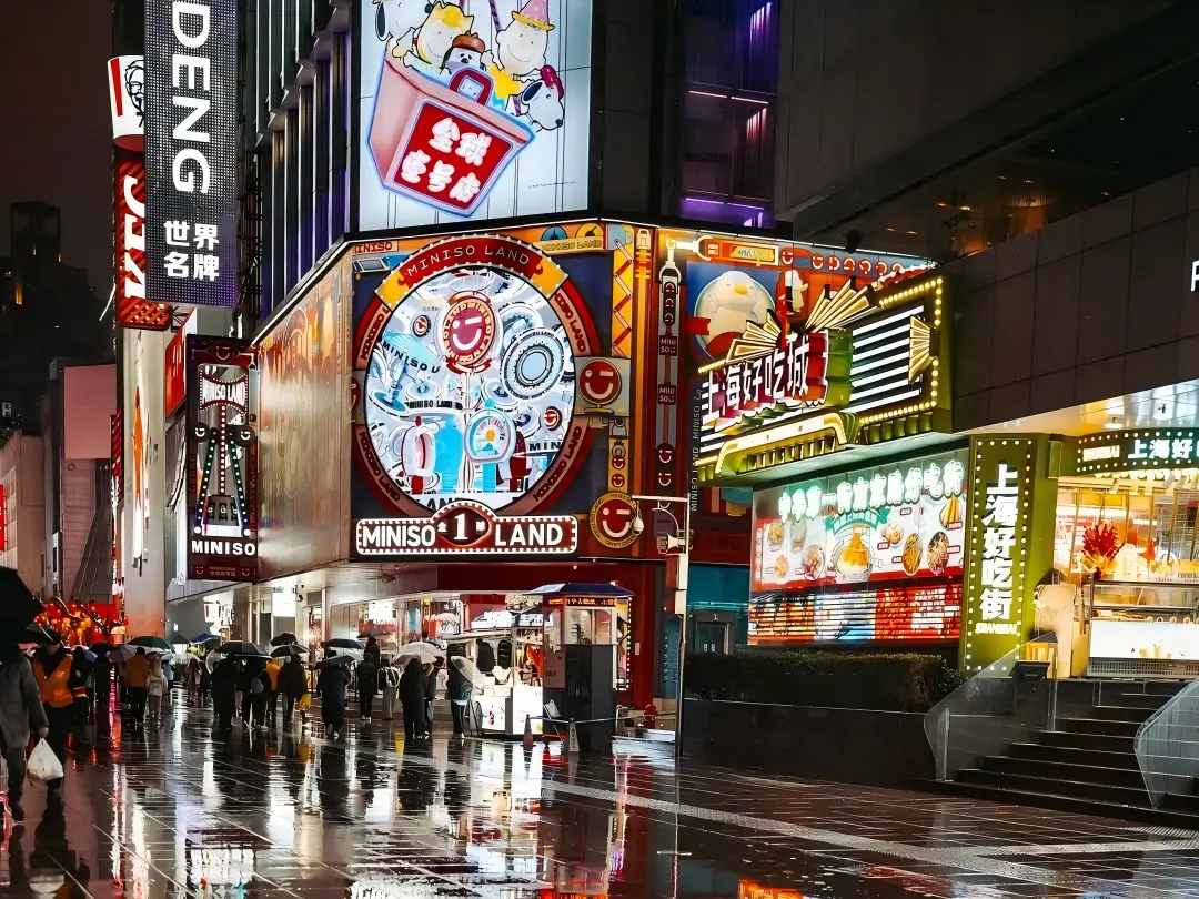 Bright neon signs and stores on rainy Nanjing Road Shanghai