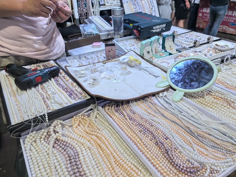 Pearl jewelry booth with loose pearl strands and handcraft tools