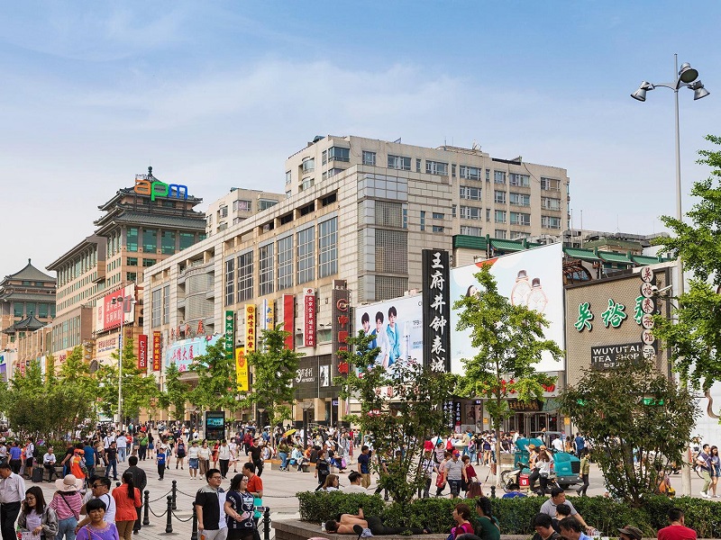 Day view of Wangfujing shopping district with visitors and store signs