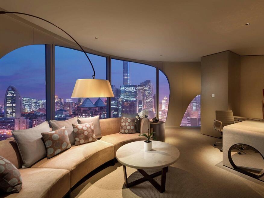 Hotel suite interior overlooking Beijing city skyline at dusk